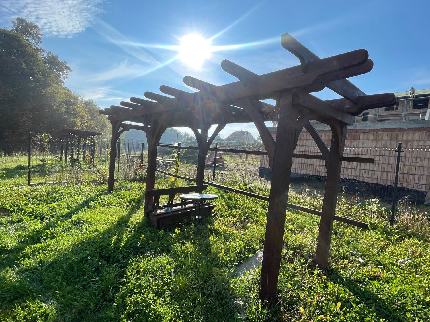 Zbiorniki, kosiarka i pergola w ogrodzie